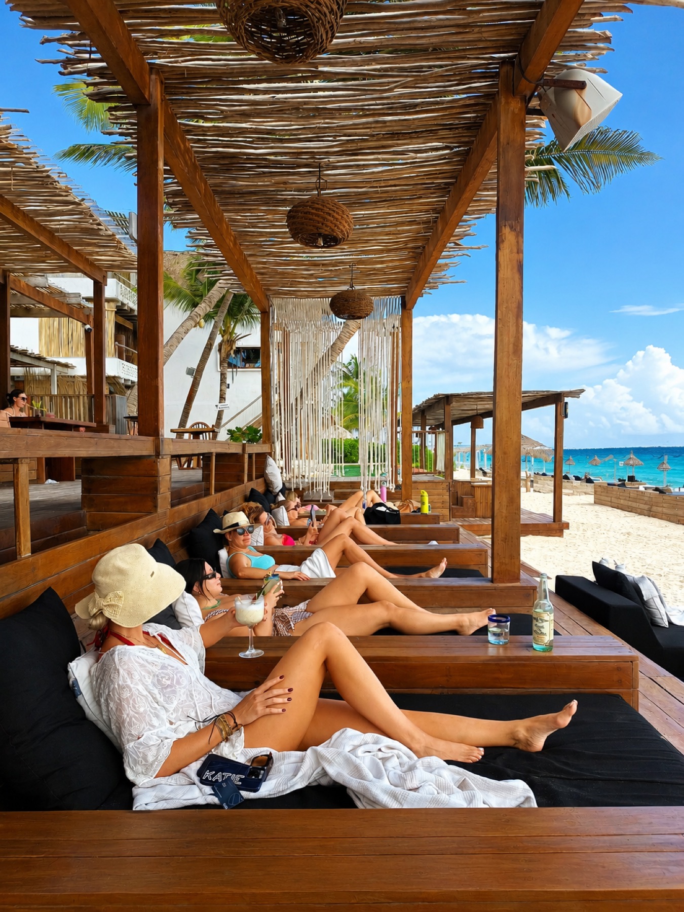 Guests lounging beachside at Amansala beach club Tulum