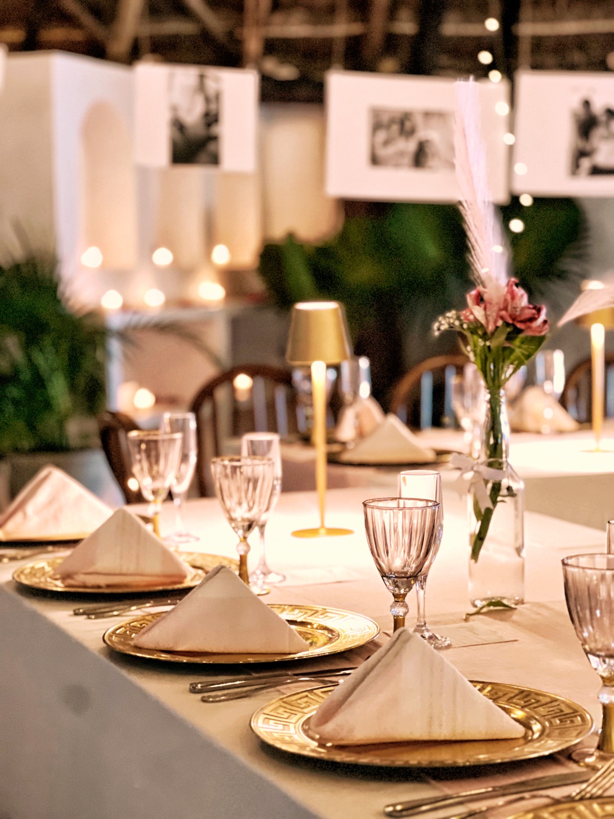 Beachfront birthday dinner table set with candles and hanging photo memory wall