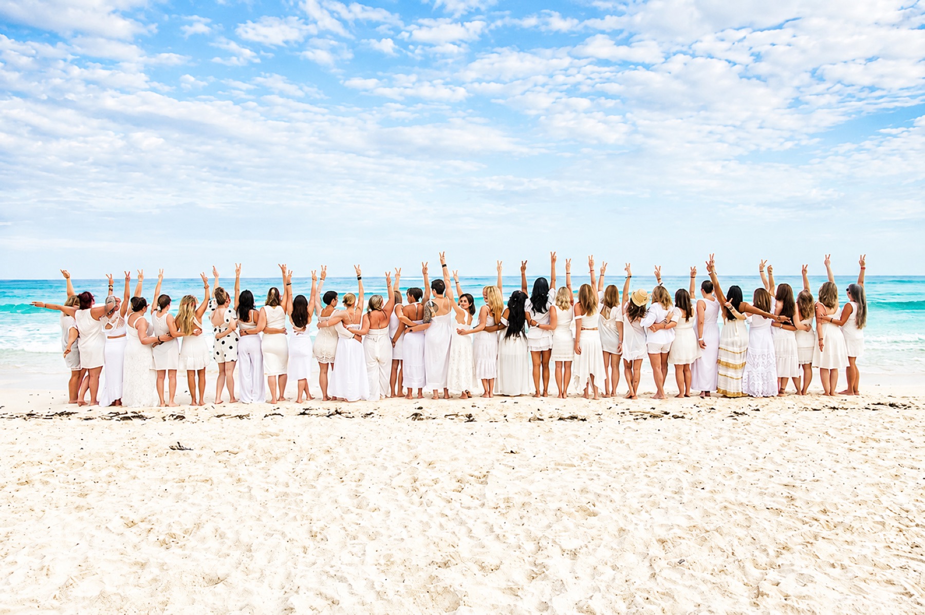 Retreat group celebrating together on the beach at Amansala Tulum