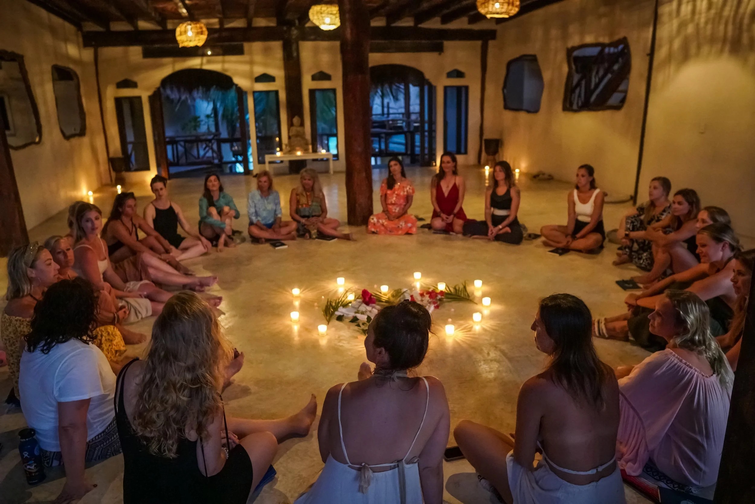 Group gathered in a candlelit circle for a wellness ceremony at Amansala Tulum