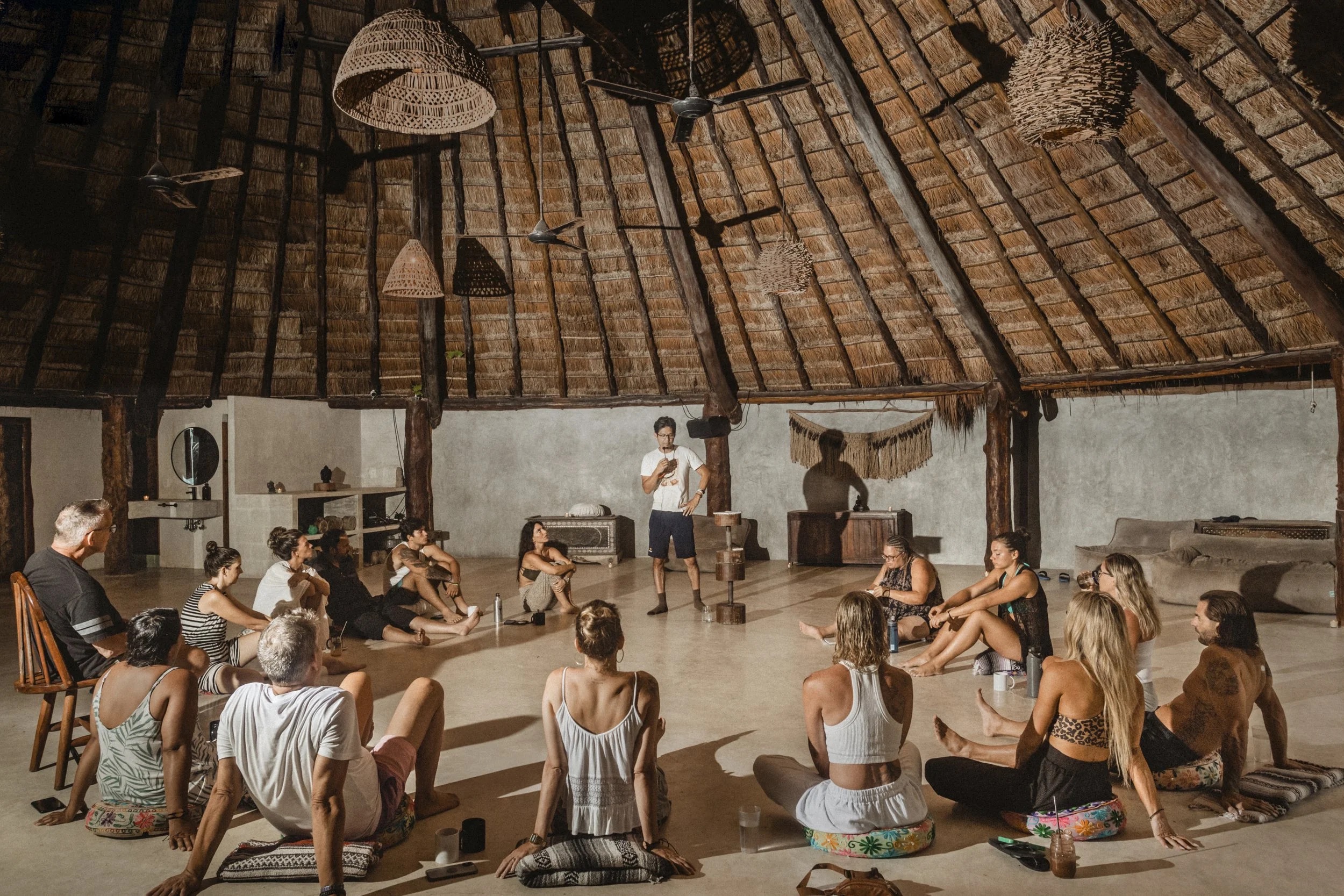 Team building workshop in a thatched-roof gathering space at Amansala Tulum
